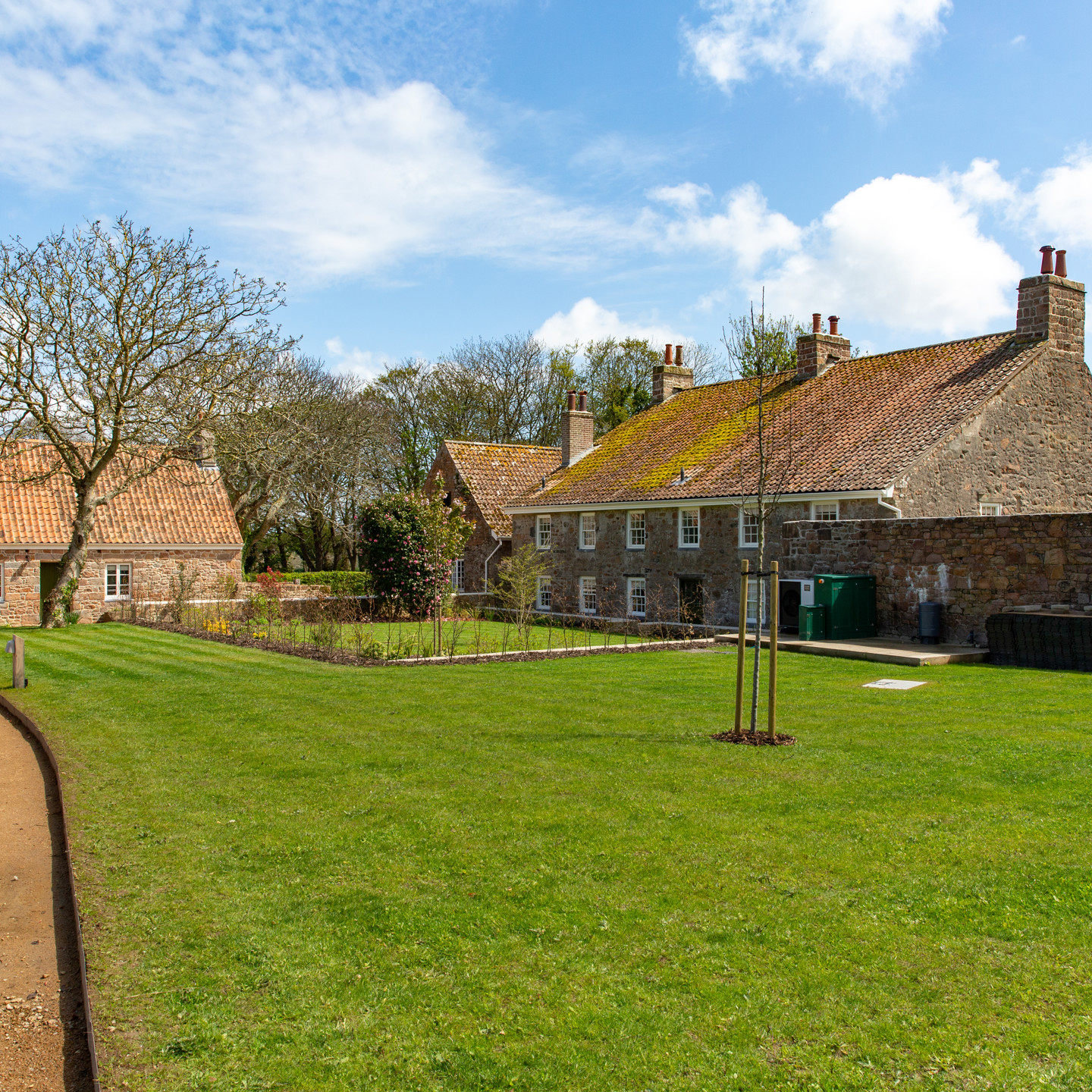 Morel Farm Complex Jersey - Granite farmhouse and cottage with green lawn and gravel drive